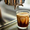 Atlantis vending machine Greater Noida dispensing coffee into a clear glass cup