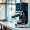 Black coffee machine Noida Sector 27 brewing espresso on a kitchen counter