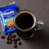 Atlantis Kadak coffee 1 kg price pack with a cup of black coffee and coffee beans