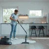 Man using steam cleaner Noida model to clean hardwood floor in modern kitchen