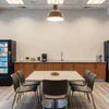 Corporate coffee machine service NCR setup in modern office break room with seating and vending machines