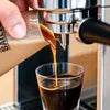 Cafe style coffee premix Noida being poured into a glass for cafe vending