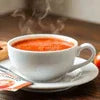 Hot tomato soup from a soup premix supplier served in a white cup for cafe vending