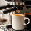 Atlantis 4 Lane tea coffee machine brewing espresso into white ceramic cup in office setting