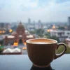Coffee premix cup with frothy coffee overlooking Delhi city view