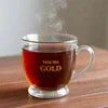 Tata Tea Gold Strong Flavor Tea in glass cup with rich amber color on wooden surface
