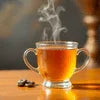 Tata Tea Gold Premium steaming cup of tea in glass mug on wooden table for office use