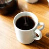 White ceramic cup filled with black instant coffee on wooden table showcasing Best Instant Coffee India
