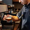 Barista preparing espresso with black and silver coffee machine for office use Tea Coffee Machine Noida