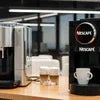 Nescafe ATLANTIS COFFEE MACHINE black model for office use with stainless steel milk frother and white cups