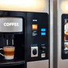 ATLANTIS COFFEE MACHINE black vending model dispensing coffee in office setting