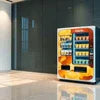 Orange ATLANTIS COFFEE MACHINE vending model in office setting with sleek black wall background