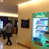 ATLANTIS PREMIX vending machine with beverages in office corridor featuring blue and green branding
