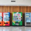 Three vending machines with ATLANTIS PREMIX branding in orange green and blue colors for office use
