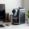 Black mini coffee machine for office Ghaziabad on desk with coffee cup in compact design