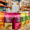 Colorful coffee bags displayed in a store with coffee machine rental options nearby