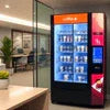 Nescafe coffee machine rental Gurugram showing a black Nescafe vending machine stocked with beverages in an office setting