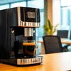 Black DeLonghi coffee machine model EC155 on office desk for coffee machine rental Gurugram