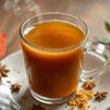 Close-up of a clear glass cup filled with coffee with spices on table near coffee machine grugram