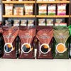 Coffee machine Grugram with various coffee bean bags in brown and green packaging for office use