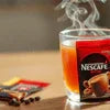 Nescafe coffee machine grugram with a glass cup of freshly brewed coffee for office use