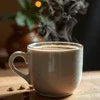 Amazon Plus instant coffee powder review showing steaming cup of coffee in a beige mug on wooden table