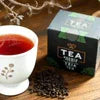 Atlantis coffee premix plus tea box with white cup of brewed tea and loose tea leaves for office use