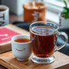 Amazon Plus tea premix online Delhi clear glass cup and white ceramic cup on wooden tray for office use