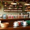 Amazon Plus tea premix suppliers Faridabad branding with tea cups and premix jars on wooden shelves in a cozy cafe setting