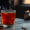 Steaming glass of Atlantis Plus Elaichi tea premix for offices, dark amber color served in clear glass