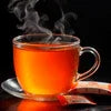 Steaming cup of tea in a clear glass cup with spoon on saucer perfect for office use with instant tea premix vending machine Gurgaon