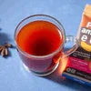 Amazon Plus tea premix price Delhi NCR shown with a glass of hot black tea and branded packaging