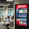 Nescafe vending machine black color stocked with coffee and snacks for office use
