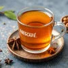 Nescafe instant tea premix for offices in glass cup with saucer showing rich amber color tea