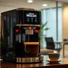 Nescafe coffee machine for office India black model brewing coffee with cup on table