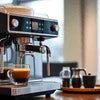 Atlantis coffee machine Mumbai review showing black commercial espresso machine brewing coffee in office setting