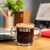 Nescafe Coffee Premix Gurgaon in glass mug on office desk with laptop and stationery