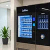 Atlantis Machine Gurgaon black coffee vending machine with digital display and multiple coffee options in office setting