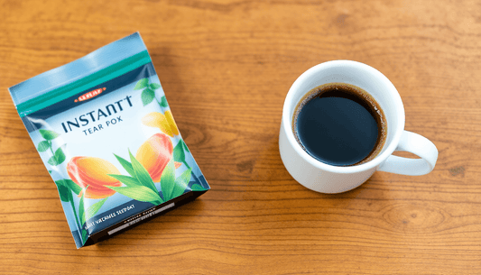 Instant tea pack beside a coffee cup on wooden table