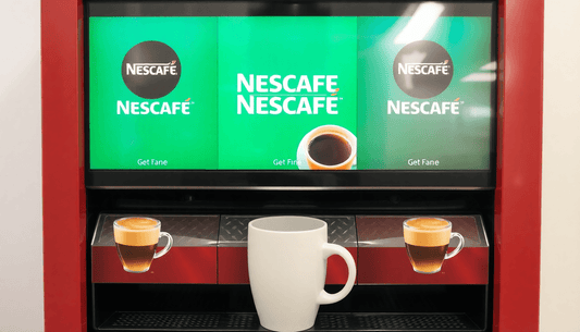 A 3 lane Nescafe coffee vending machine dispensing coffee