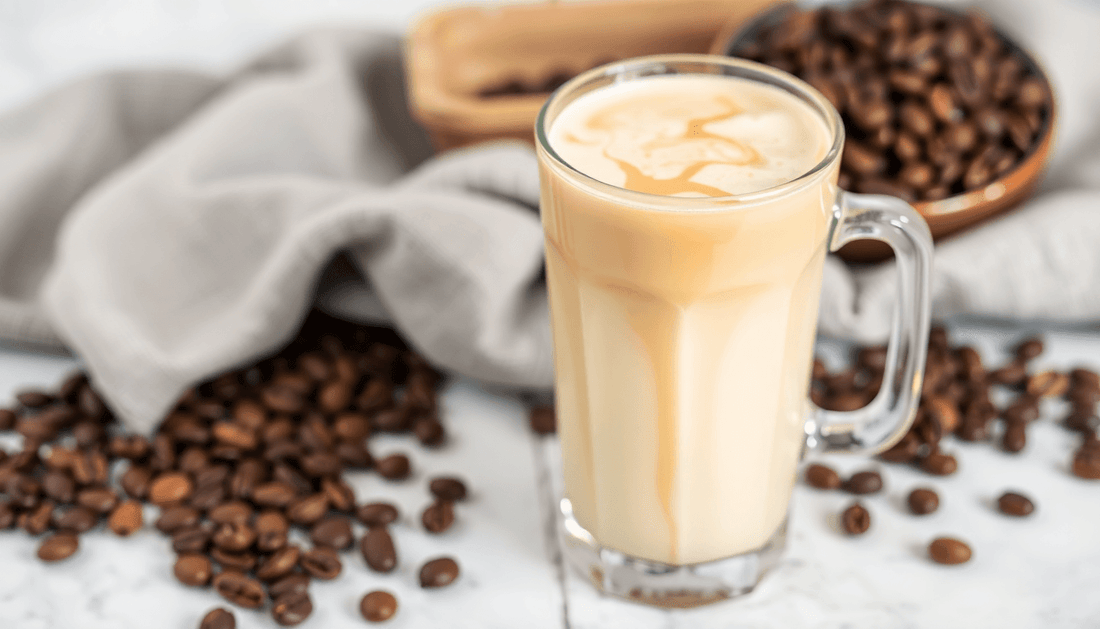 A glass of creamy vanilla cold coffee with coffee beans