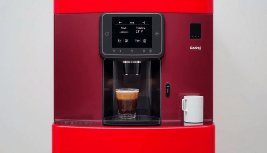 A sleek Godrej automatic coffee vending machine dispensing coffee