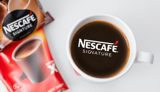 A cup of Nescafe Signature coffee with packaging nearby