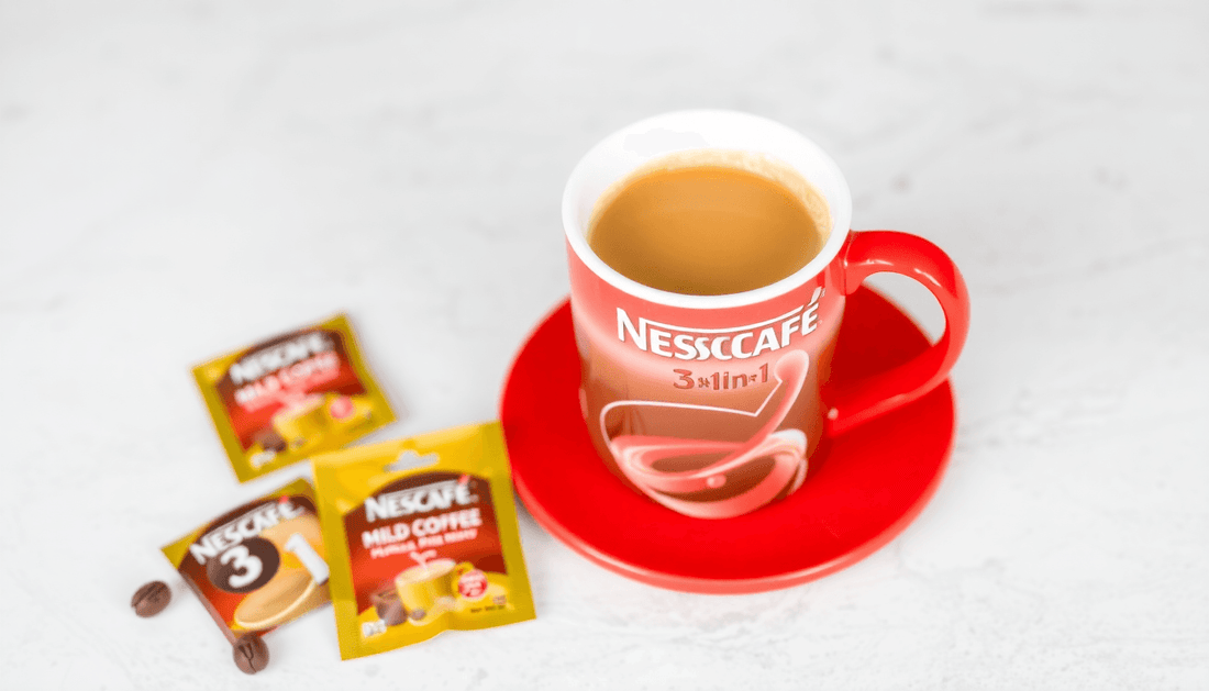 A cup of NESCAFÉ 3 in 1 Mild Coffee Premix with sachets