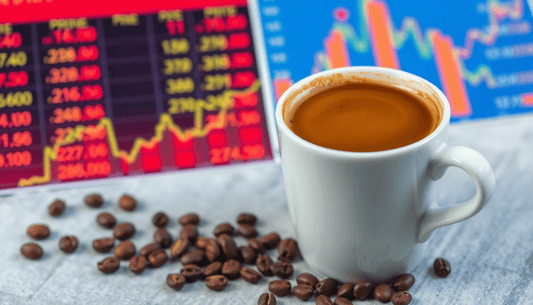 A cup of Arabica coffee with price charts in background