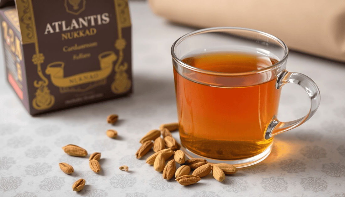 A cup of cardamom tea with cardamom pods and Atlantis Nukkad packaging