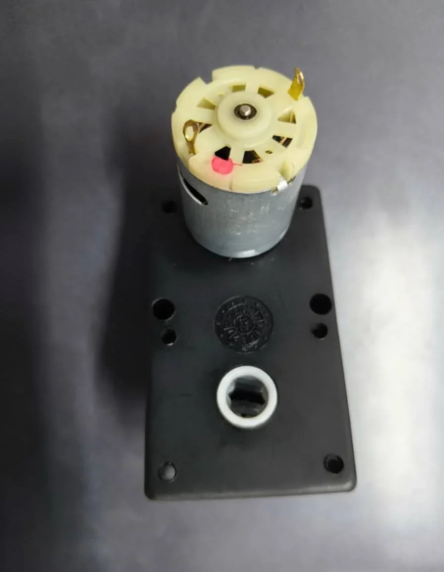 Close-up of a small electric motor component on a black plastic base used in Amazon tea premix Noida products