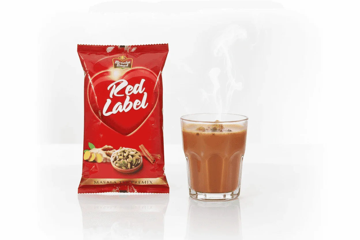 COFFEE WALLA Red label masla tea premix 1 kg packet beside a steaming glass of masala tea