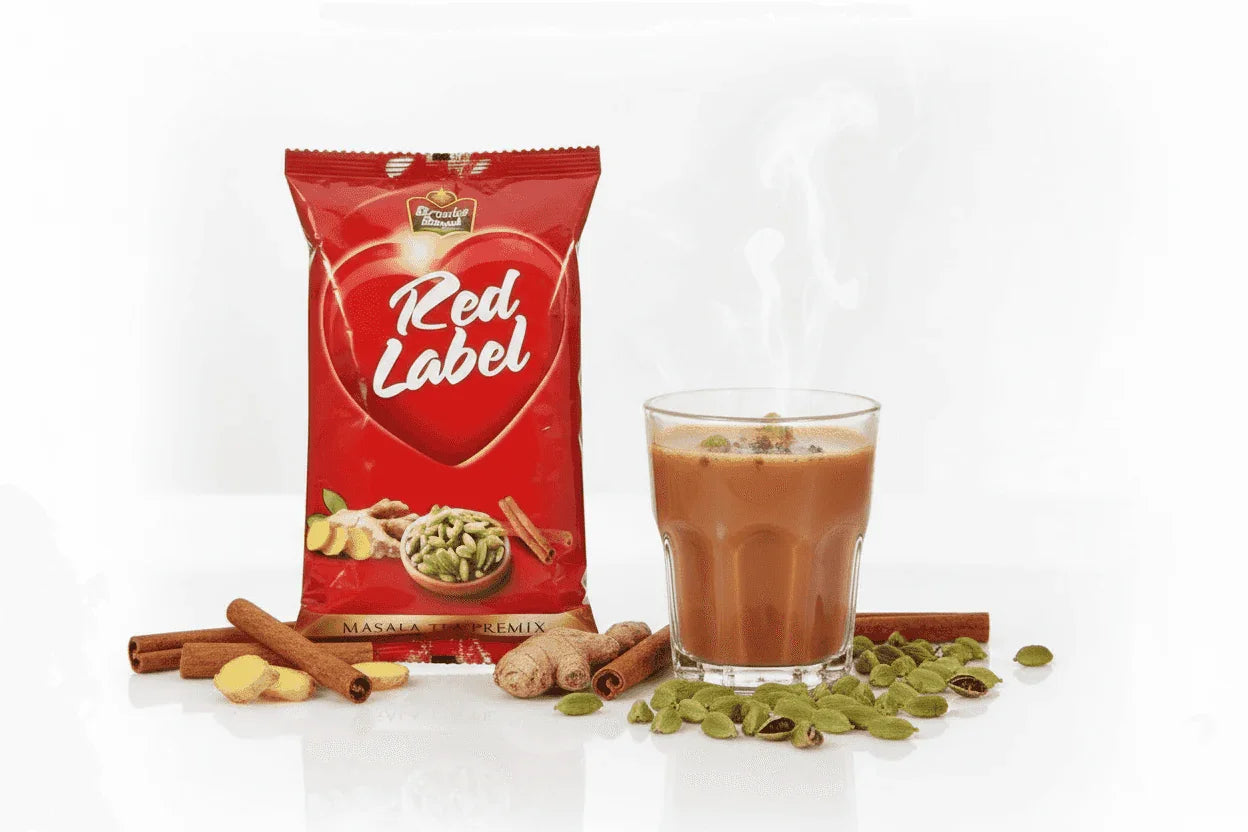 Red label masla tea premix 1 kg packet with a glass of steaming masala chai and spices by Coffee Walla
