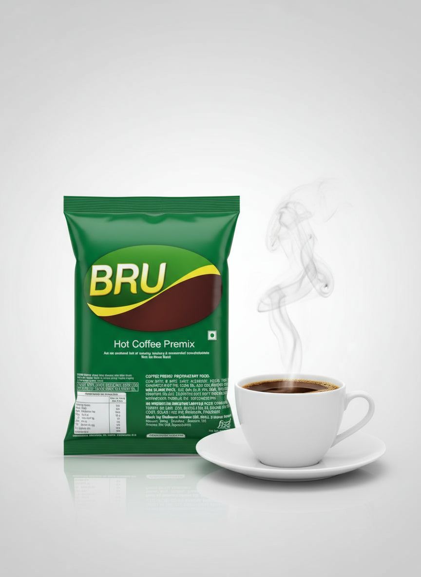 Hot Bru Coffee Premix 1kg green pack next to steaming cup of coffee on white saucer
